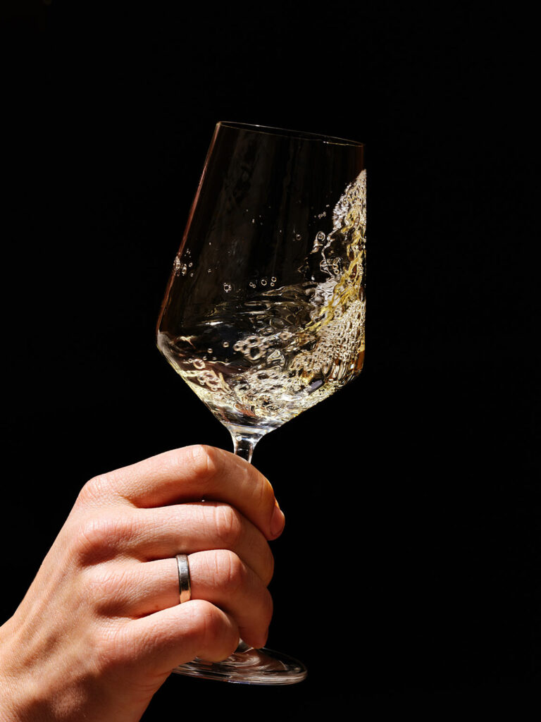 Hand mit einem Weinglas