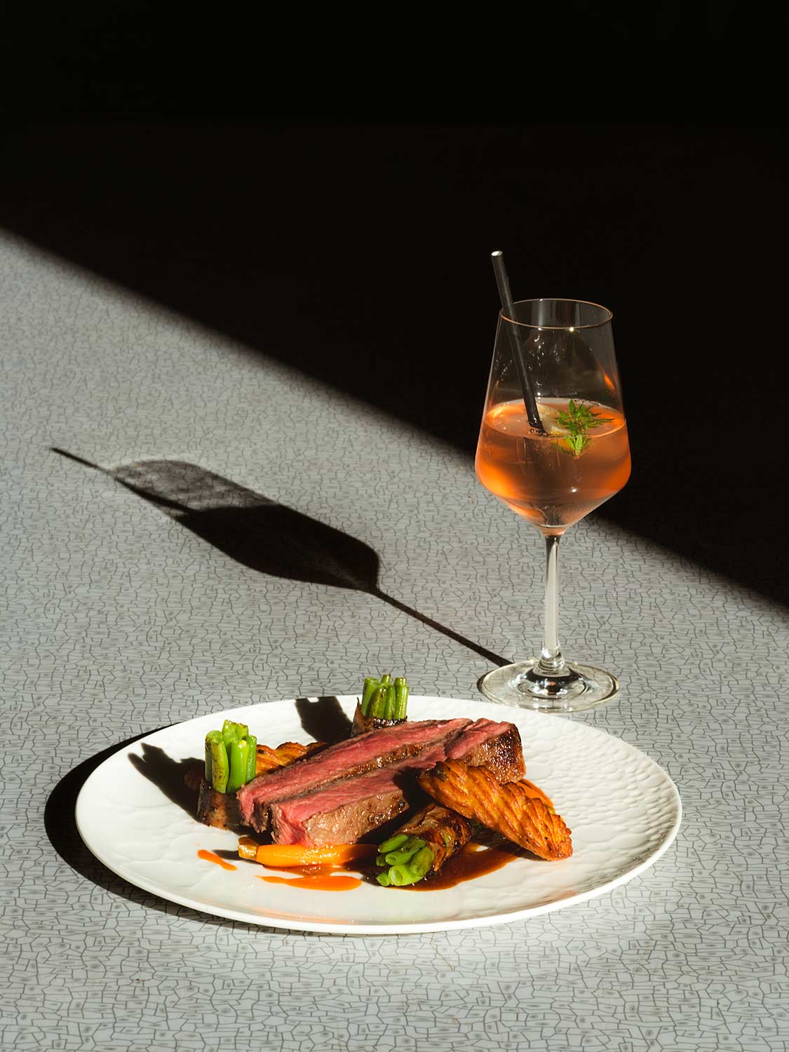 Teller mit Roastbeef und ein Weinglas mit einem Getränk